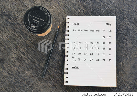 May 2026 desk calendar with disposable coffee cup and pen on wooden table. Directly above. Flat lay 142172435