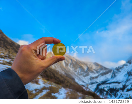 Hand Holding Bitcoin Coin in Snowy Kyrgyzstan Mountains Hand Holding Bitcoin Coin in Snowy Kyrgyzstan Mountains 142172839