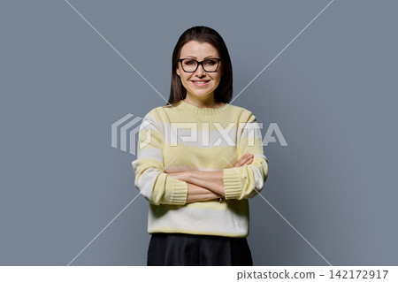 Confident smiling mature woman in glasses with arms crossed studio portrait Confident smiling mature woman in glasses with arms crossed studio portrait 142172917