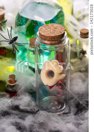 Spooky Halloween potions and spooky decorations in glass bottles with spider webs for festive fall holiday celebrations Spooky Halloween potions and spooky decorations in glass bottles with spider webs for festive fall holiday celebrations 142173028