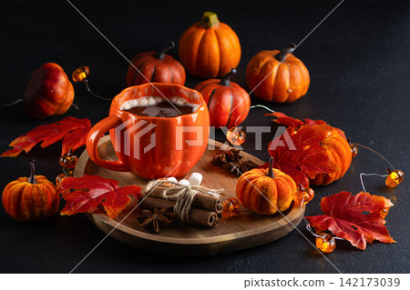 Autumnal warm beverage with pumpkin decorations and cinnamon sticks perfect for fall holidays Autumnal warm beverage with pumpkin decorations and cinnamon sticks perfect for fall holidays 142173039