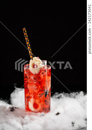 Spooky Halloween Cocktail with Ice Cubes and Ghost Garnish Decorated with Fake Spiders and Cobwebs Spooky Halloween Cocktail with Ice Cubes and Ghost Garnish Decorated with Fake Spiders and Cobwebs 142173041