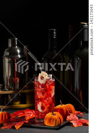 Spooky Halloween cocktail with eyeball garnish and mini pumpkins festive decoration and bar tools background Spooky Halloween cocktail with eyeball garnish and mini pumpkins festive decoration and bar tools background 142173043