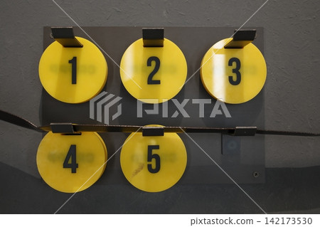 Sequential yellow numbers on gray display panel Sequential yellow numbers on gray display panel 142173530