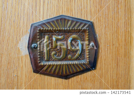 Decorative house number 159 on rustic wooden door Decorative house number 159 on rustic wooden door 142173541