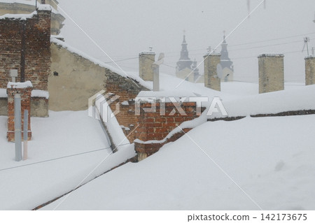 Snow covers old brick rooftops and church towers in Lviv during winter Snow covers old brick rooftops and church towers in Lviv during winter 142173675