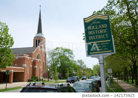Holland, United States, May 14 2018: Historic downtown sign with brick church and tall steeple Holland, United States, May 14 2018: Historic downtown sign with brick church and tall steeple 142173925