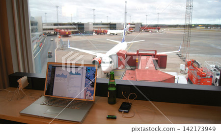 Stockholm, Sweden, December 10 2015: Working in airline lounge with apron view and aircraft at gate 142173949