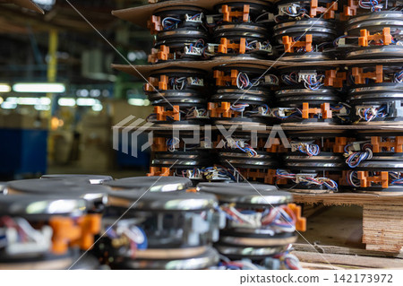 Stacked industrial components with orange connectors and multicolored wiring in factory setting Stacked industrial components with orange connectors and multicolored wiring in factory setting 142173972