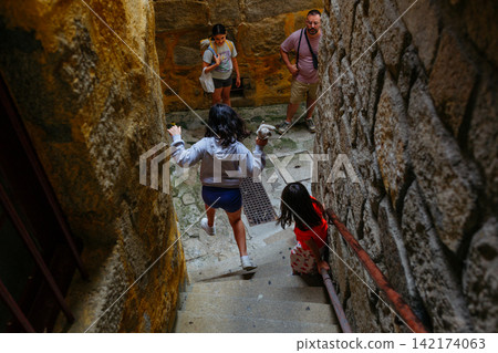 A Girl Jumping Down Stone Steps in Historic Porto Portugal 142174063