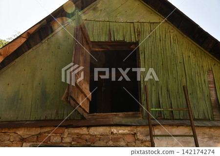 Interior of the attic of house with boxes and old appliances under gable roof Interior of the attic of house with boxes and old appliances under gable roof 142174274