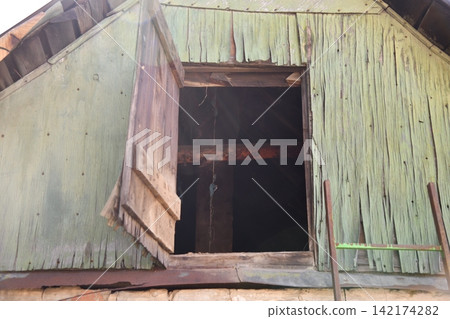 Interior of the attic of house with boxes and old appliances under gable roof Interior of the attic of house with boxes and old appliances under gable roof 142174282