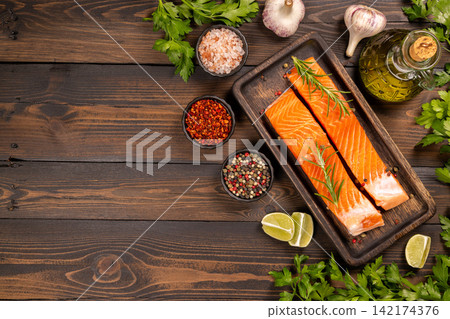 Fresh salmon fillets with herbs, spices, and cooking ingredients Fresh salmon fillets with herbs, spices, and cooking ingredients 142174376