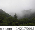 Mountains covered in fog 142175098