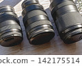Three camera lenses illuminated by oblique light. 142175514