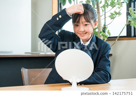 Girls in uniforms styling their hair in the mirror, elementary school students, junior high school students (bangs) 142175751