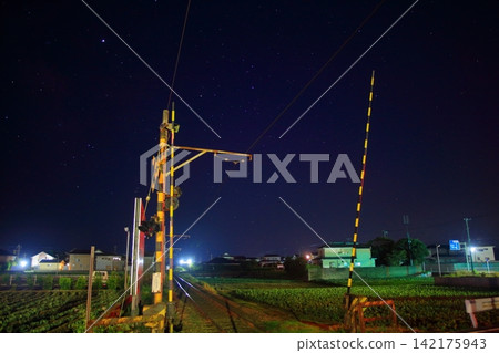 A winter night illuminated by a sky full of stars and the Choshi Electric Railway level crossing. A winter night illuminated by a sky full of stars and the Choshi Electric Railway level crossing. 142175943