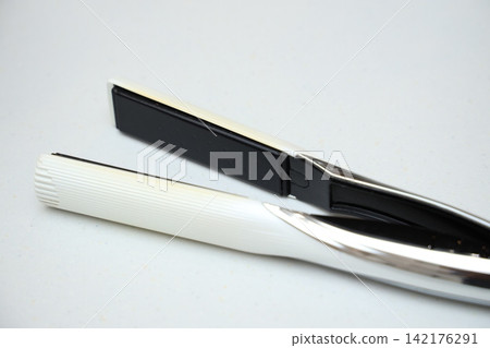 Hair irons and beauty appliances against a bright white background Hair irons and beauty appliances against a bright white background 142176291