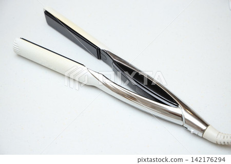 Hair irons and beauty appliances against a bright white background Hair irons and beauty appliances against a bright white background 142176294