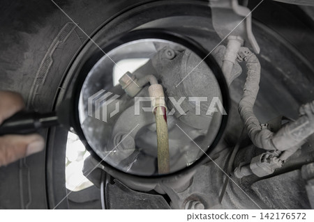Car leaking brake hose at a connector on rear wheel. Car leaking brake hose at a connector on rear wheel. 142176572