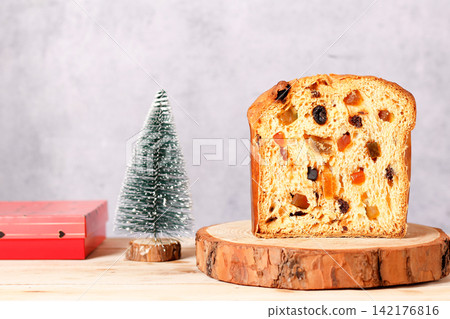Sliced Christmas panettone with candied fruit and raisins on a rustic wooden base with space for text Sliced Christmas panettone with candied fruit and raisins on a rustic wooden base with space for text 142176816