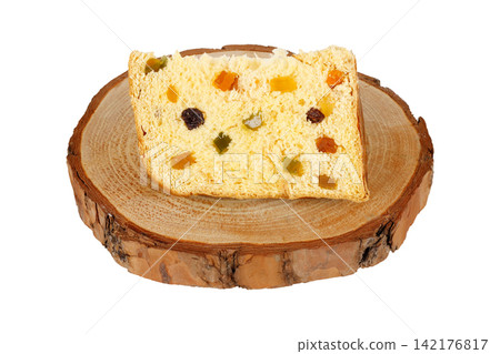 Slice of Christmas panettone with candied fruit and raisins on a rustic wooden base, isolated on a white background Slice of Christmas panettone with candied fruit and raisins on a rustic wooden base, isolated on a white background 142176817