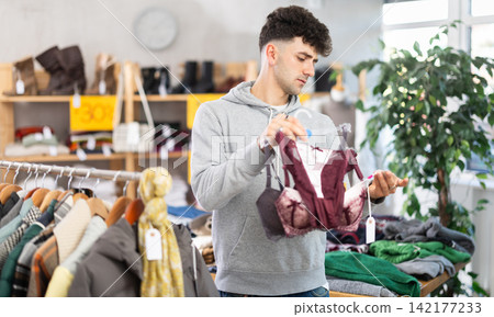 Young guy choosing lace bras in clothing store Young guy choosing lace bras in clothing store 142177233