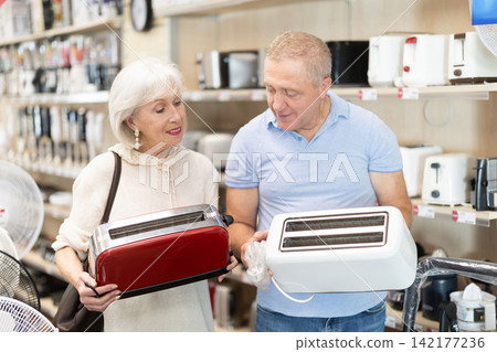 Elderly couple choosing toaster at household appliances store Elderly couple choosing toaster at household appliances store 142177236