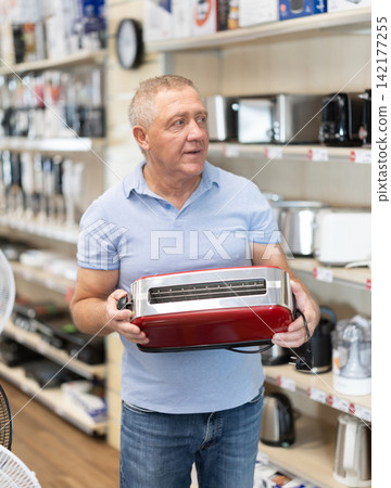 Elderly man buys a modern toaster for his new kitchen Elderly man buys a modern toaster for his new kitchen 142177255