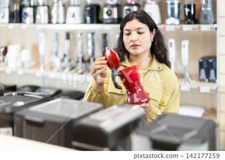 Latina woman chooses a coffee maker 142177259
