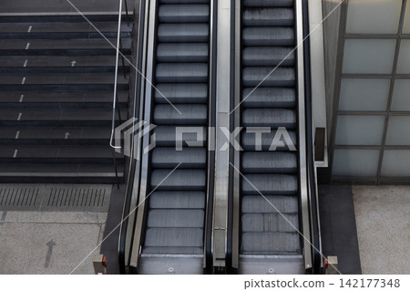 Escalators provide efficient vertical movement in busy city setting Escalators provide efficient vertical movement in busy city setting 142177348