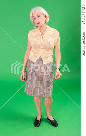 Sad elderly woman looking upset in front of green screen 142177429