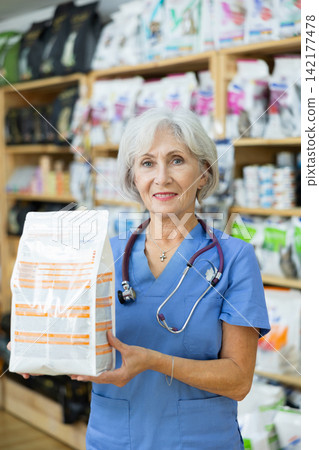 Smiling female veterinarian recommending healthy dry pet food Smiling female veterinarian recommending healthy dry pet food 142177478
