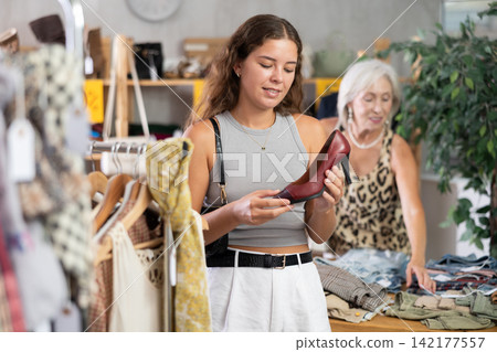 Young woman choosing high heel shoes in store 142177557