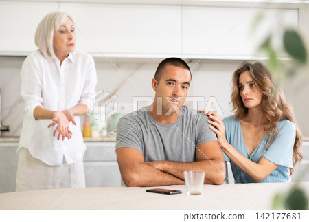Elderly woman quarrels with couple in kitchen 142177681
