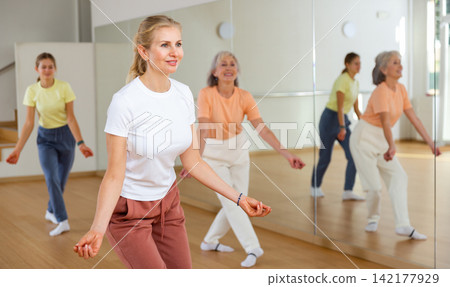Female doing dance workout during group classe in fitness center Female doing dance workout during group classe in fitness center 142177929