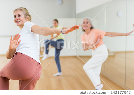 Woman dancing during group class Woman dancing during group class 142177942