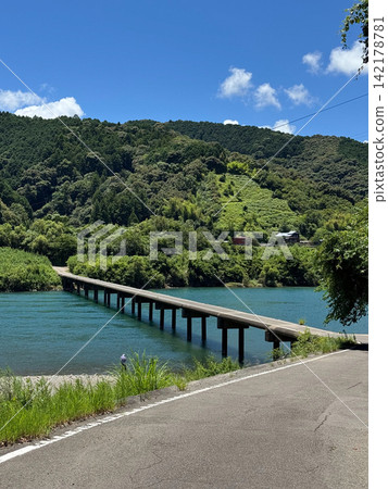 A scene of a submersible bridge crossing a clear stream under a summer sky. A scene of a submersible bridge crossing a clear stream under a summer sky. 142178781