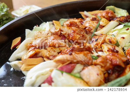 Spicy Korean Chicken Stir Fry Dakgalbi with Vegetables on Iron Pan Spicy Korean Chicken Stir Fry Dakgalbi with Vegetables on Iron Pan 142178934