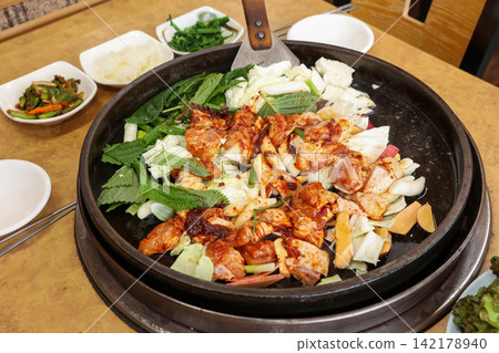 Spicy Korean Chicken Stir Fry Dakgalbi with Vegetables on Iron Pan Spicy Korean Chicken Stir Fry Dakgalbi with Vegetables on Iron Pan 142178940