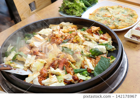 Spicy Korean Chicken Stir Fry Dakgalbi with Vegetables on Iron Pan Spicy Korean Chicken Stir Fry Dakgalbi with Vegetables on Iron Pan 142178967