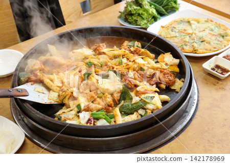 Spicy Korean Chicken Stir Fry Dakgalbi with Vegetables on Iron Pan Spicy Korean Chicken Stir Fry Dakgalbi with Vegetables on Iron Pan 142178969