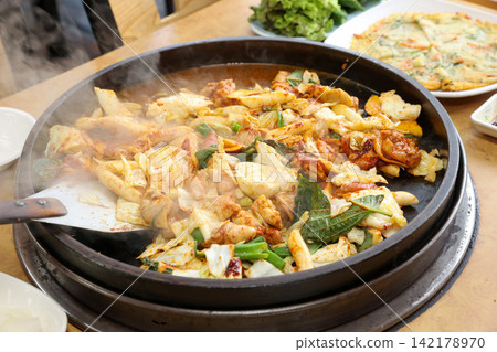 Spicy Korean Chicken Stir Fry Dakgalbi with Vegetables on Iron Pan Spicy Korean Chicken Stir Fry Dakgalbi with Vegetables on Iron Pan 142178970