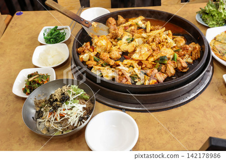 Spicy Korean Chicken Stir Fry Dakgalbi with Vegetables on Iron Pan Spicy Korean Chicken Stir Fry Dakgalbi with Vegetables on Iron Pan 142178986