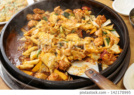 Spicy Korean Chicken Stir Fry Dakgalbi with Vegetables on Iron Pan Spicy Korean Chicken Stir Fry Dakgalbi with Vegetables on Iron Pan 142178995