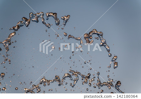 Splashes and jets of water against light background. Splashes and jets of water against light background. 142180364