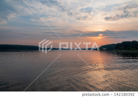 Lake with pine and birch forest on the shores at summer or early autumn sunset. Lake with pine and birch forest on the shores at summer or early autumn sunset. 142180392
