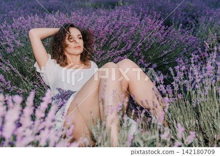 Lavender, woman, field, beautiful young lady relaxing in purple blooming flowers wearing white dress during a sunny summer day in Provence 142180709
