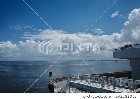 A loop bridge and observation deck on the expressway spanning Tokyo Bay, with a summer sky and towering cumulonimbus clouds in Kisarazu City, Chiba Prefecture. A loop bridge and observation deck on the expressway spanning Tokyo Bay, with a summer sky and towering cumulonimbus clouds in Kisarazu City, Chiba Prefecture. 142182012