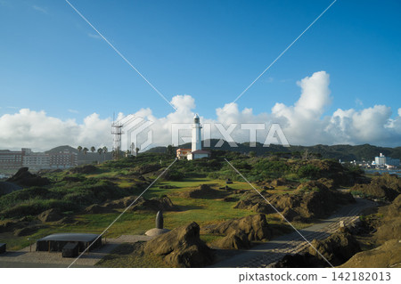 千葉縣,野島崎燈塔,夏日天空下的燈塔,以及沿海的岩石海岸和草地景觀。 千葉縣,野島崎燈塔,夏日天空下的燈塔,以及沿海的岩石海岸和草地景觀。 142182013
